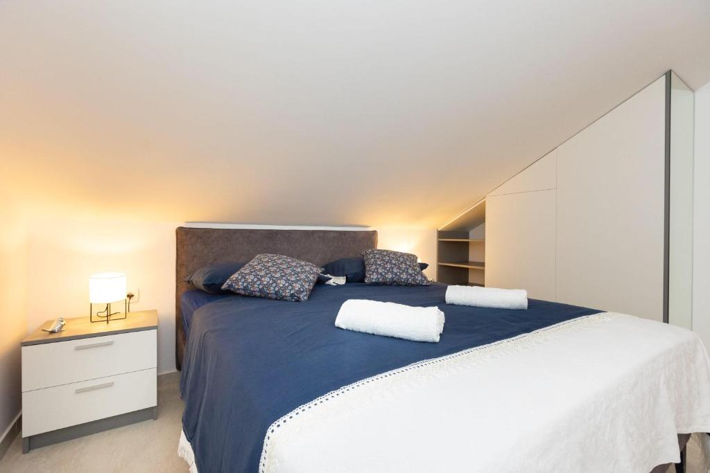 een slaapkamer met een groot bed met blauwe lakens en kussens bij Tomas Deluxe II in Dubrovnik