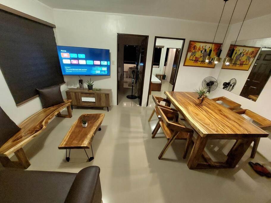 een woonkamer met houten tafels en een televisie bij Serene Victoria 