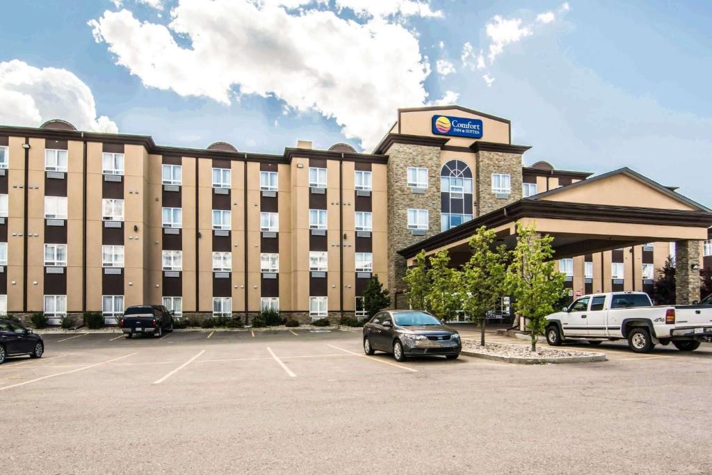 un gran edificio con coches estacionados en un estacionamiento en Comfort Inn & Suites en Fort Saskatchewan