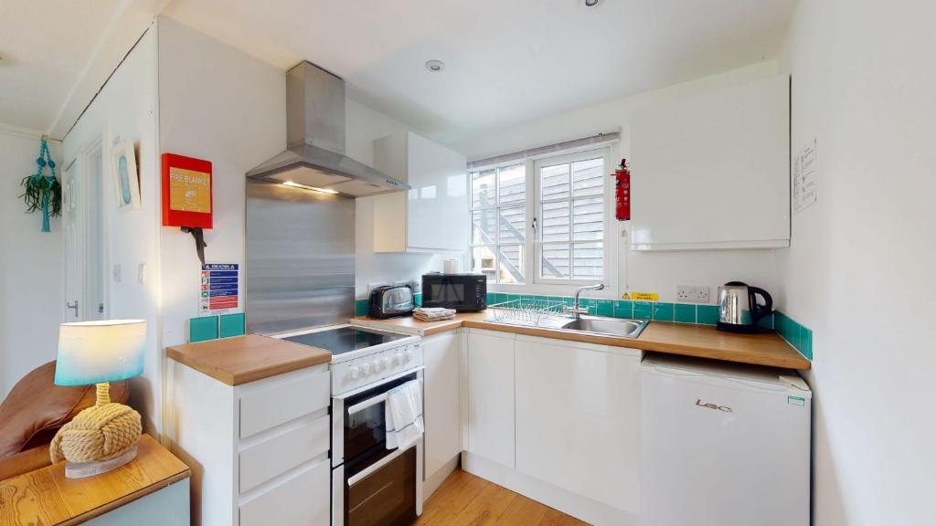 a kitchen with white cabinets and a stove top oven at 31 Tudor Court, Tolroy Manor in Hayle