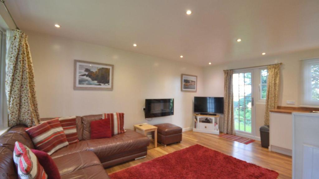 a living room with a couch and a television at 36 Tudor Court, Tolroy Manor in Hayle