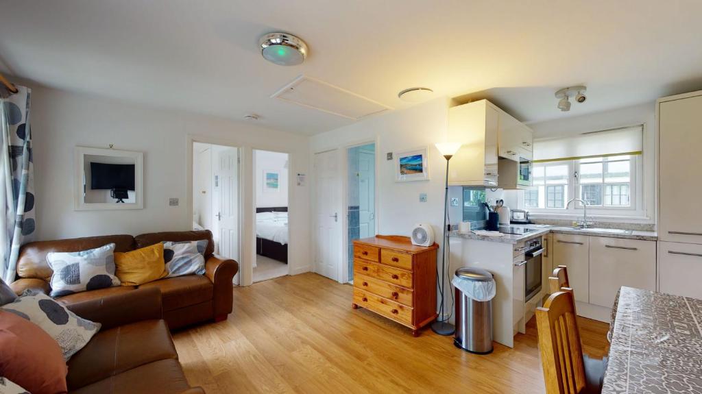 a living room with a couch and a kitchen at 28 Tudor Court, Tolroy Manor in Hayle