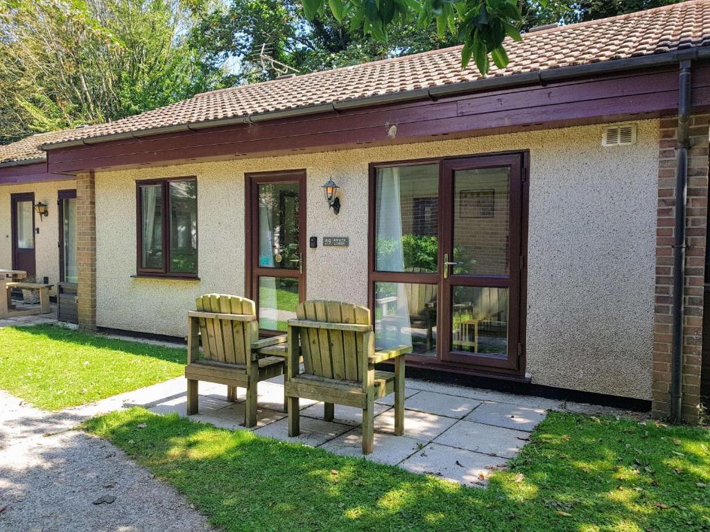 dos sillas y una mesa frente a una casa en 59 Trevithick Court, Tolroy Manor, en Hayle