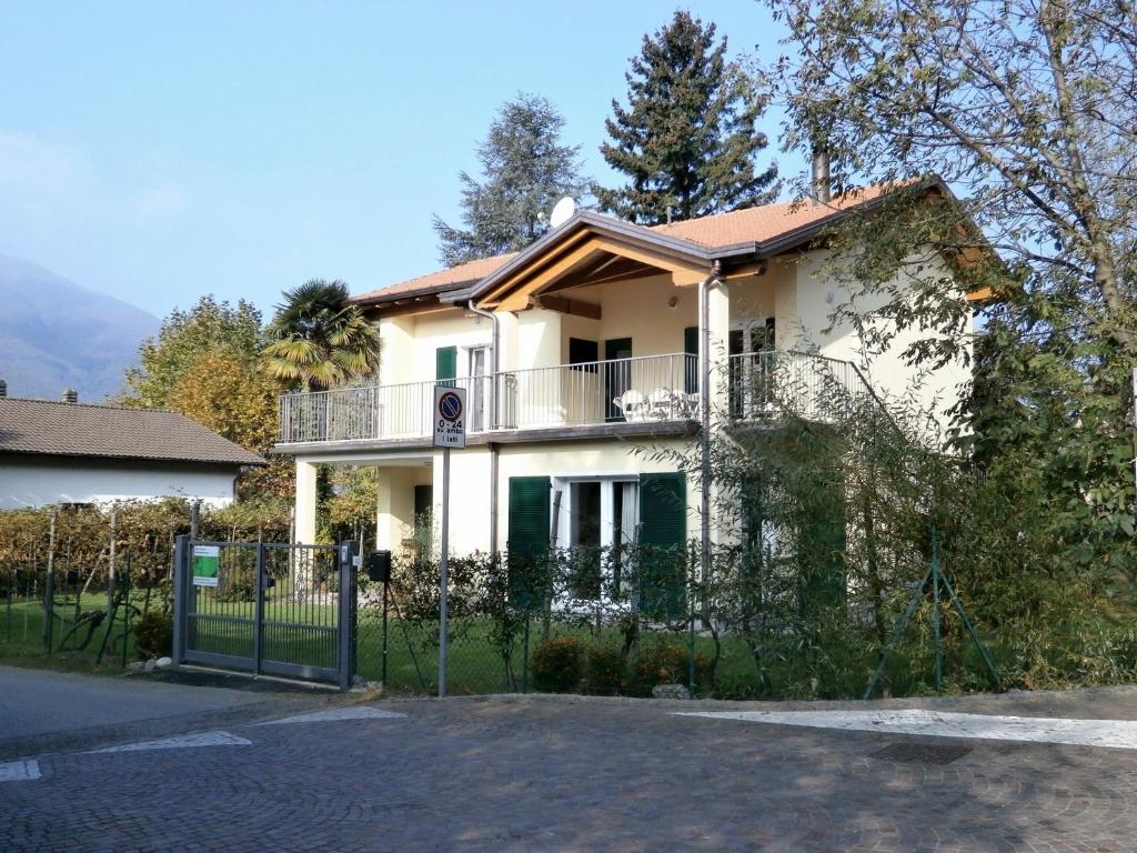 a white house with a fence in front of it at Casamanax in Maccagno Inferiore