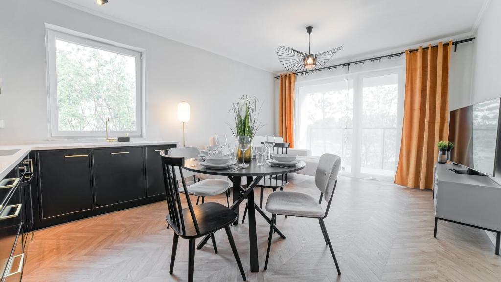 Apartament Olivia - ACCO RENT في غدانسك: مطبخ وغرفة طعام مع طاولة وكراسي