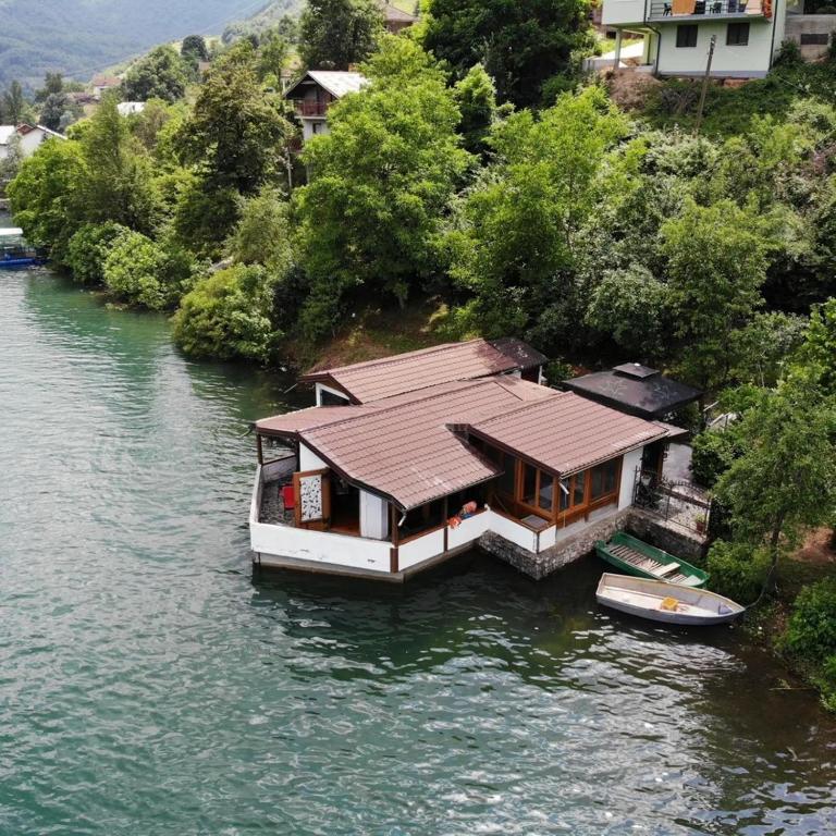 a house on a boat in the water at Holiday Home Nur in Konjic
