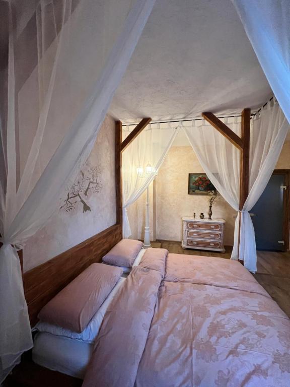 ein Schlafzimmer mit einem großen Bett mit Vorhängen in der Unterkunft Apartment Chalet mit Kamin in Plauen