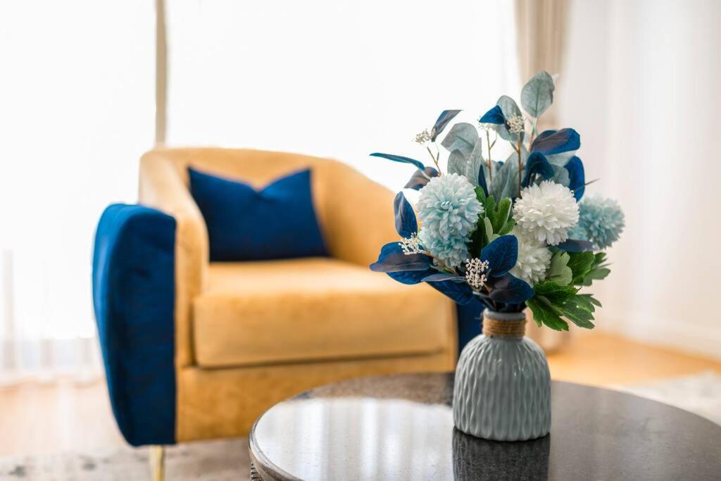 a vase of flowers on a table with a chair at Home Sweet Home in Nairobi