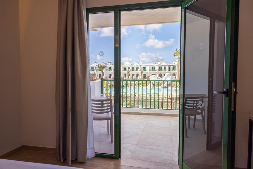 a room with a balcony with a view of the pool at MYND Yaiza in Playa Blanca