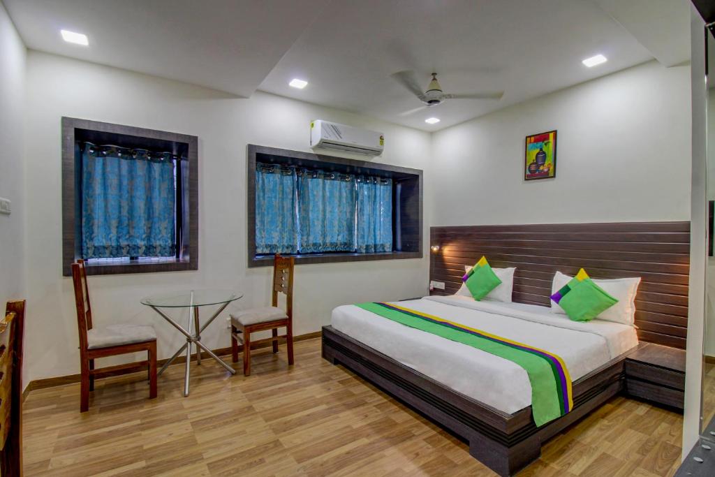 a bedroom with a bed and a table and chairs at Treebo Trend Seven Suites in Nagpur