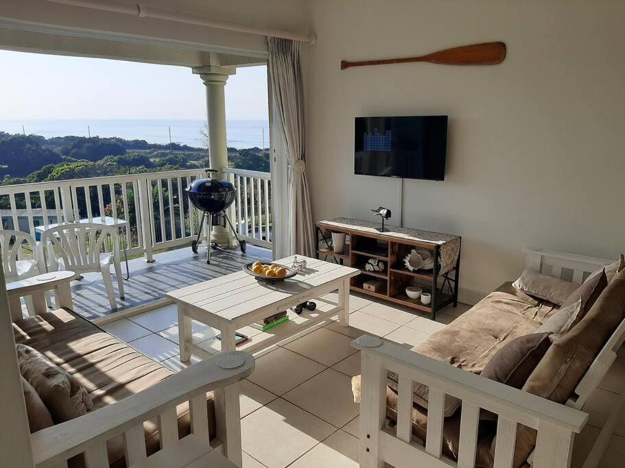 a living room with a couch and a table at Umkhomo Place, Mangrove Beach Estate in Port Shepstone