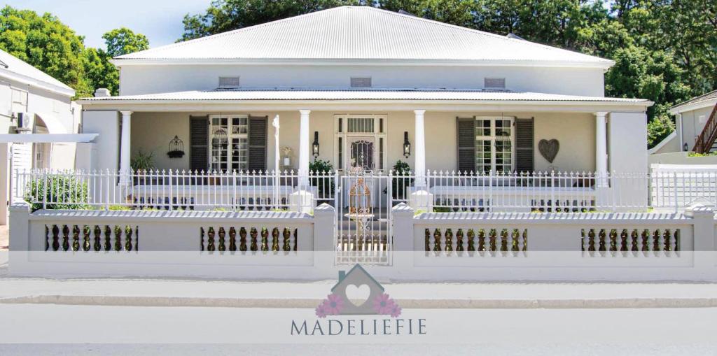 a white house with a white picket fence at Madeliefie Guest Accommodation in Paarl