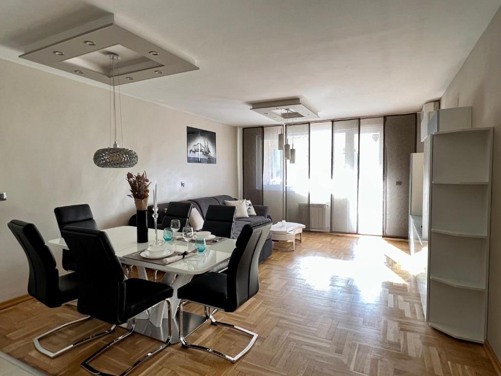 a living room with a table and black chairs at Flower house 6 in Sofia