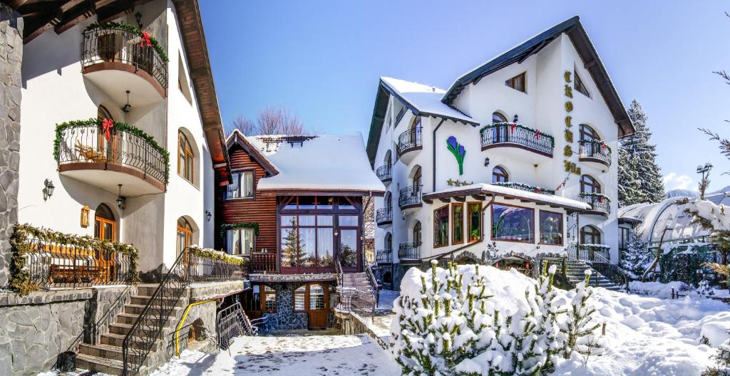 a house with snow on the ground at Pensiunea Crocus - Sauna & Billiard in Poiana Brasov