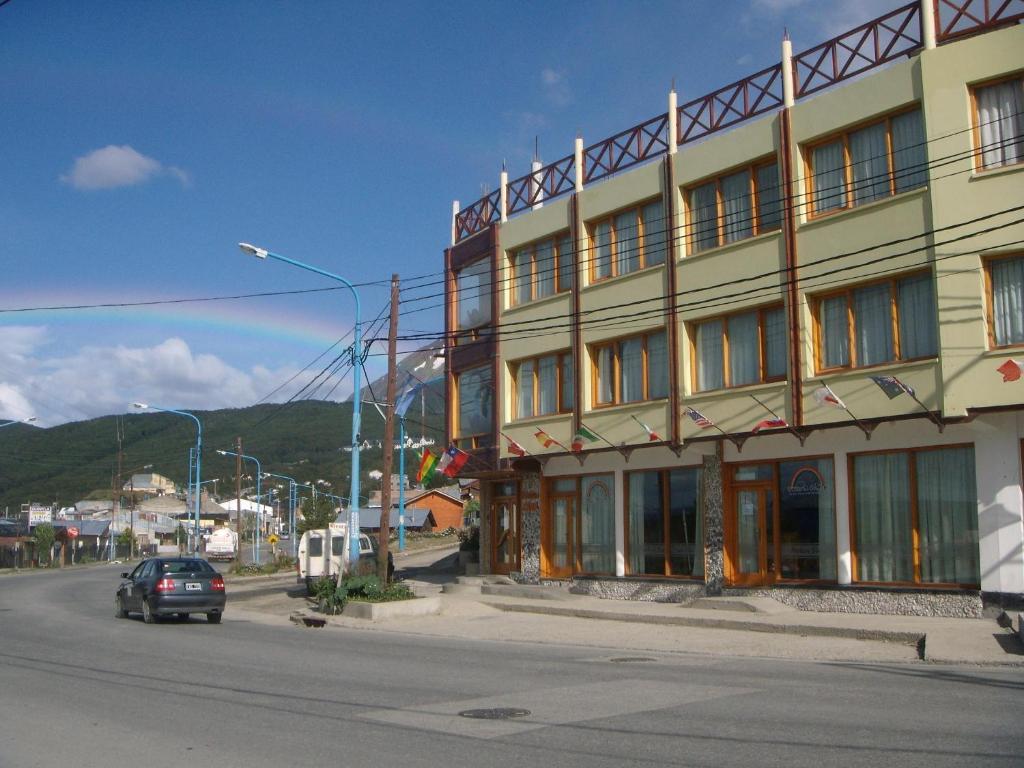 un coche pasando un edificio en una calle en Hosteria Chalp en Ushuaia