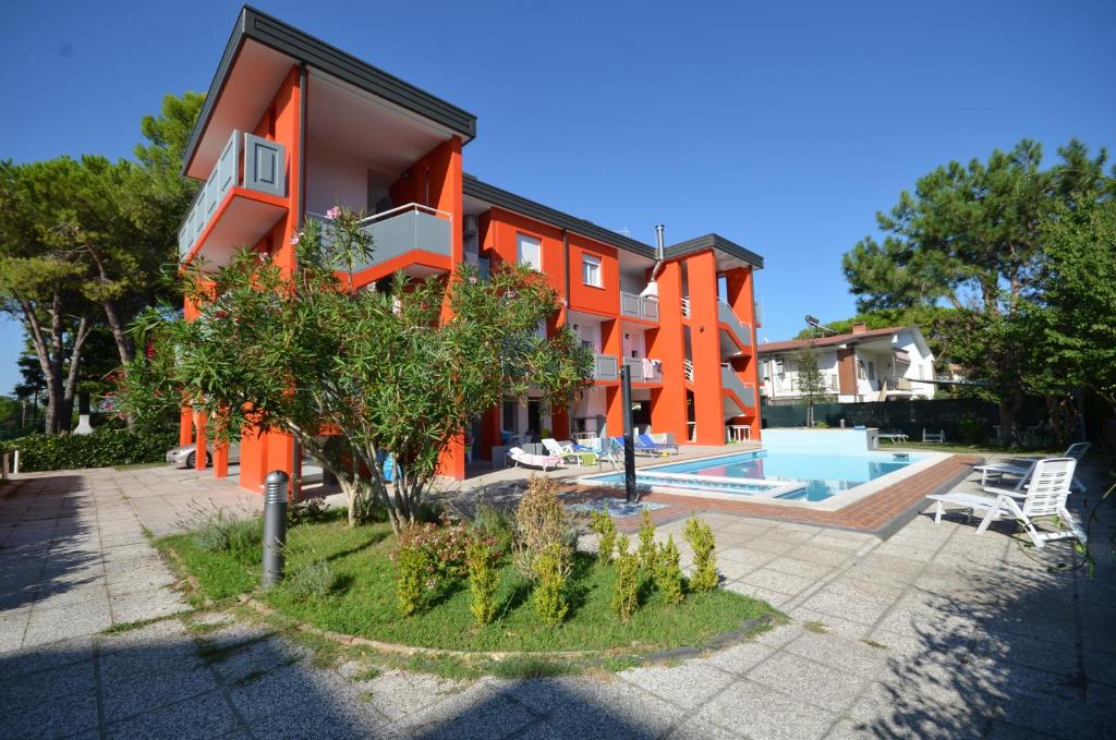 ビビオーネにあるAppartamenti Villa Simonaの中庭とスイミングプール付きのオレンジ色の建物