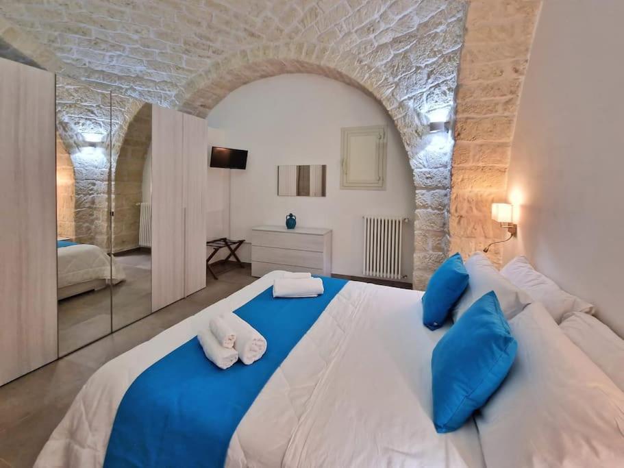 - une chambre avec un grand lit blanc et des oreillers bleus dans l'établissement Da zia Giovanna Apartment, à Manfredonia