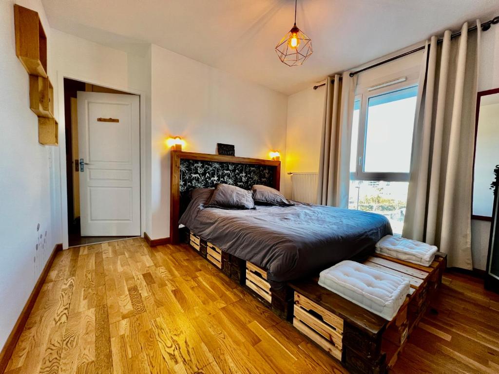 une chambre avec un lit et une grande fenêtre dans l'établissement Superbe appartement cosy, à Annecy