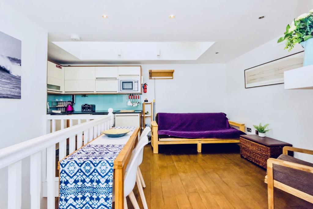 a living room with a table and a kitchen at Mews House in Brighton & Hove