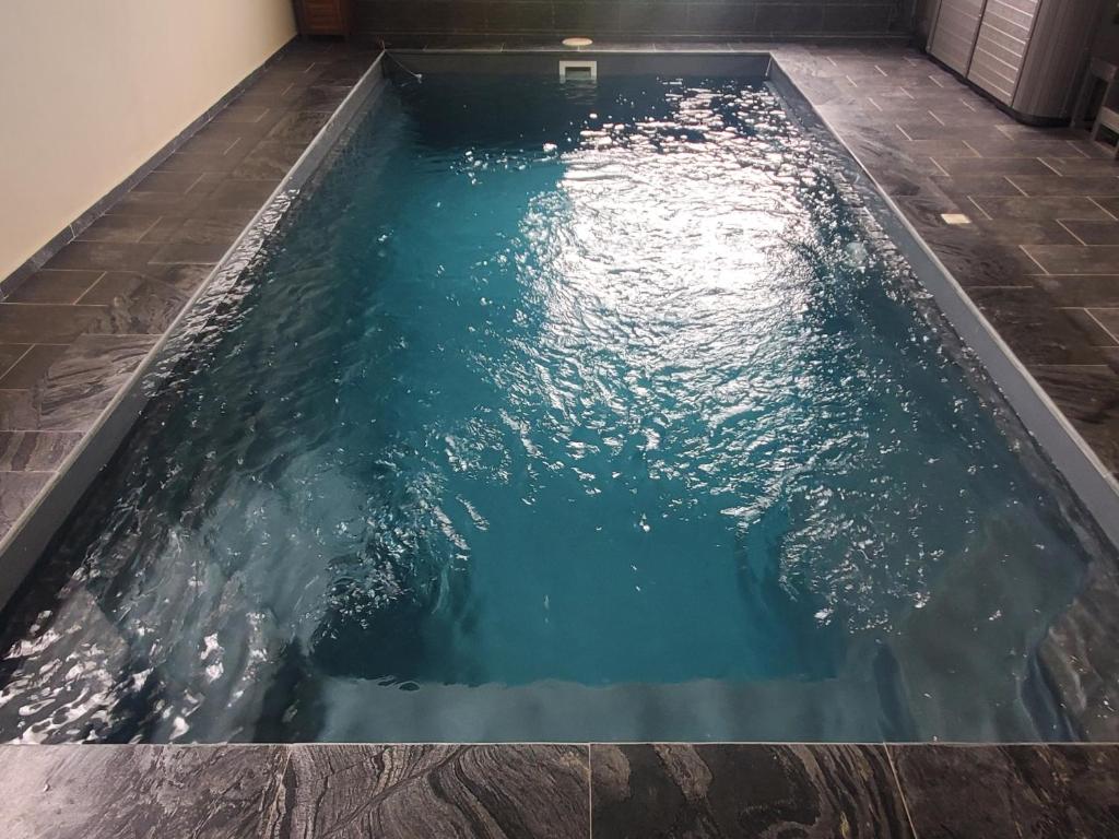 - une piscine d'eau bleue dans une chambre dans l'établissement Le Margaret Holidays, à La Plaine des Cafres
