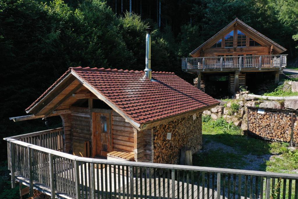 斯堪肯塞爾的住宿－Schwarzwald Romantikhütte *kuschelig *einzigartig，小木屋设有门廊和甲板