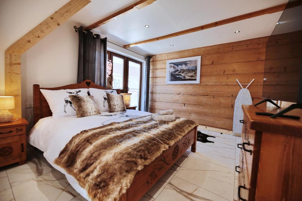 um quarto com uma cama grande e um cobertor de pele falso em WILLA SZELIGÓWKA KOŚCIELISKO em Kościelisko