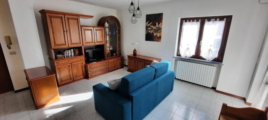 a living room with a blue couch and a tv at A casa di Vera - Vivi la tua Valle d'Aosta in Nus