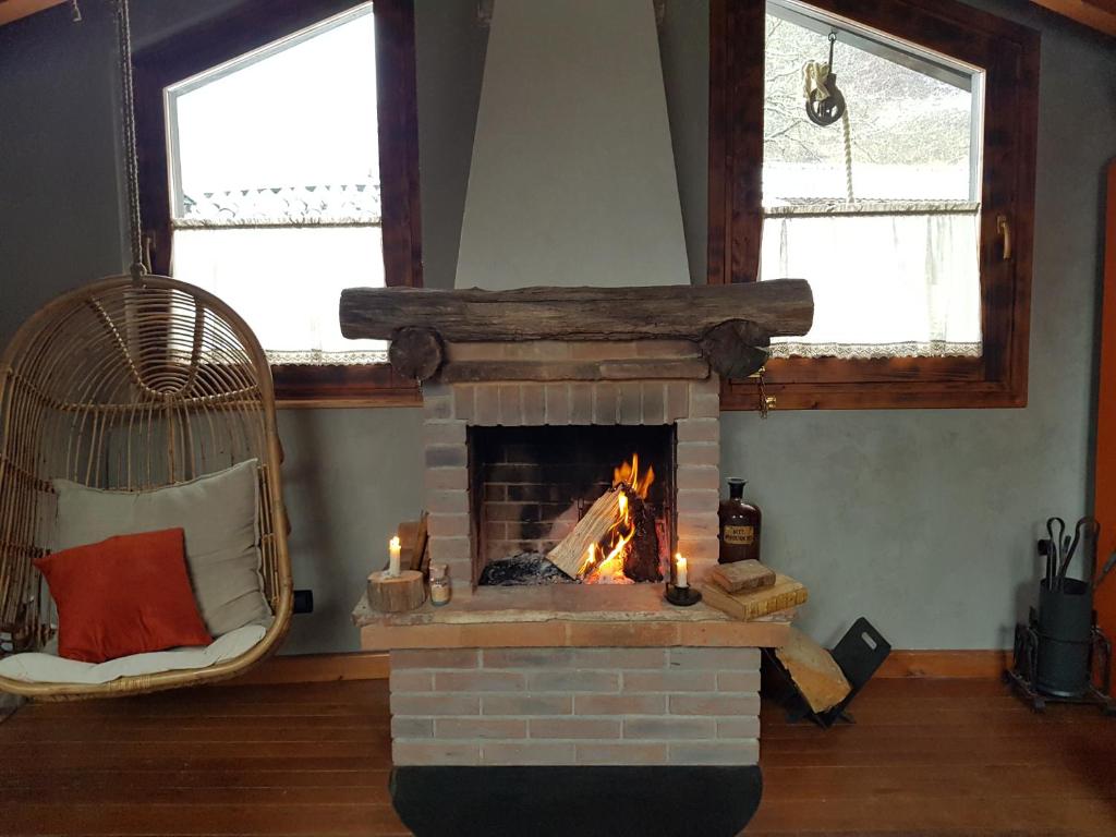 a living room with a fireplace with two windows at La Bottega del Drago in Santa Brigida