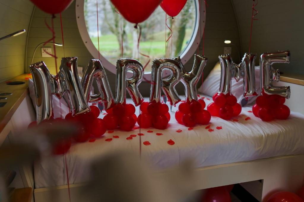 a cake in the shape of the word love with red balloons at RiverBeds - Luxury Wee Lodges with Hot Tubs in Glencoe