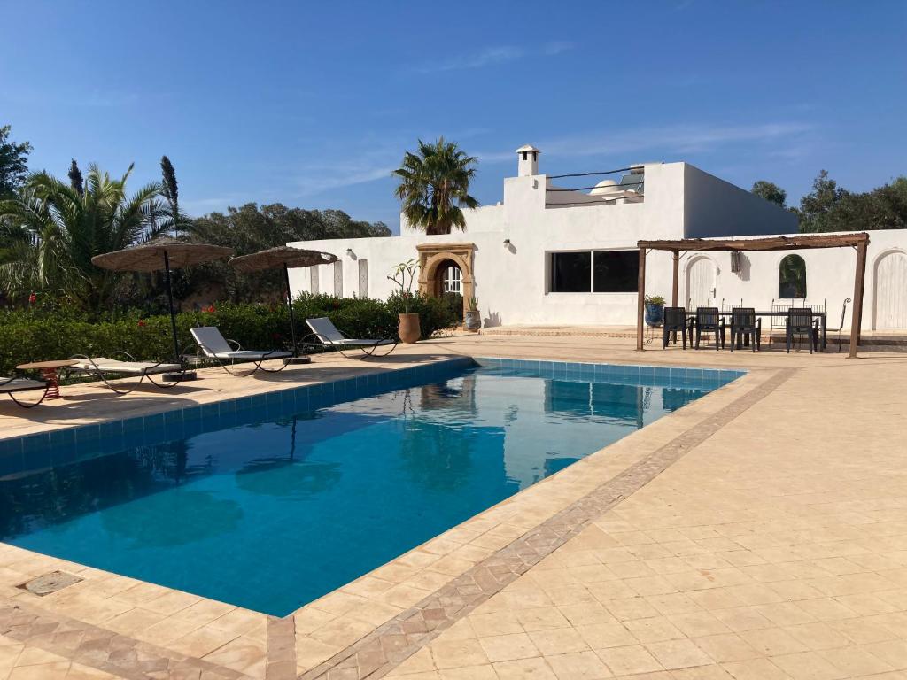 uma piscina em frente a uma casa branca em Villa Mogador em Essaouira