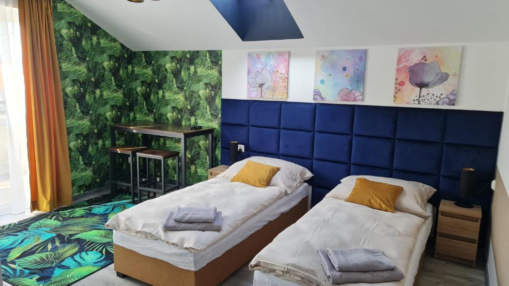 a bedroom with two beds and a blue wall at Eldom-Noclegi Rogozińska 29E in Wągrowiec