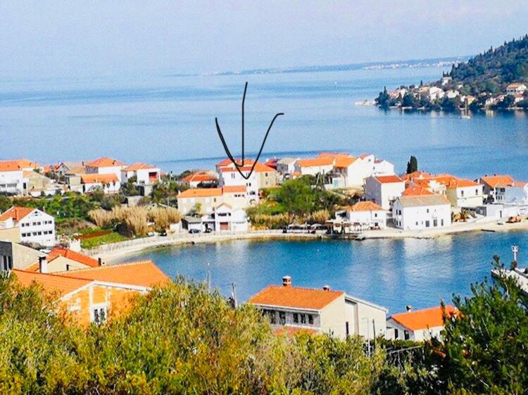a small town on the water with houses at Apartmani Blažo in Kali