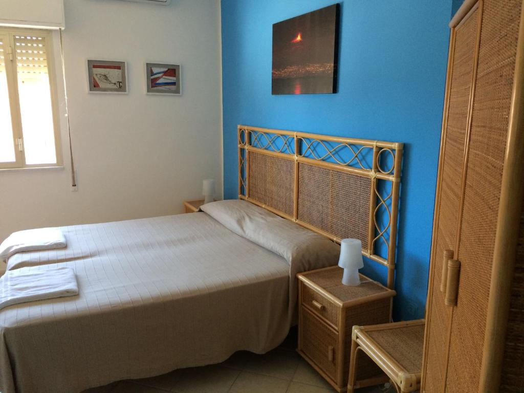 1 dormitorio con 2 camas y pared azul en Hotel Il Triangolo, en Agnone Bagni