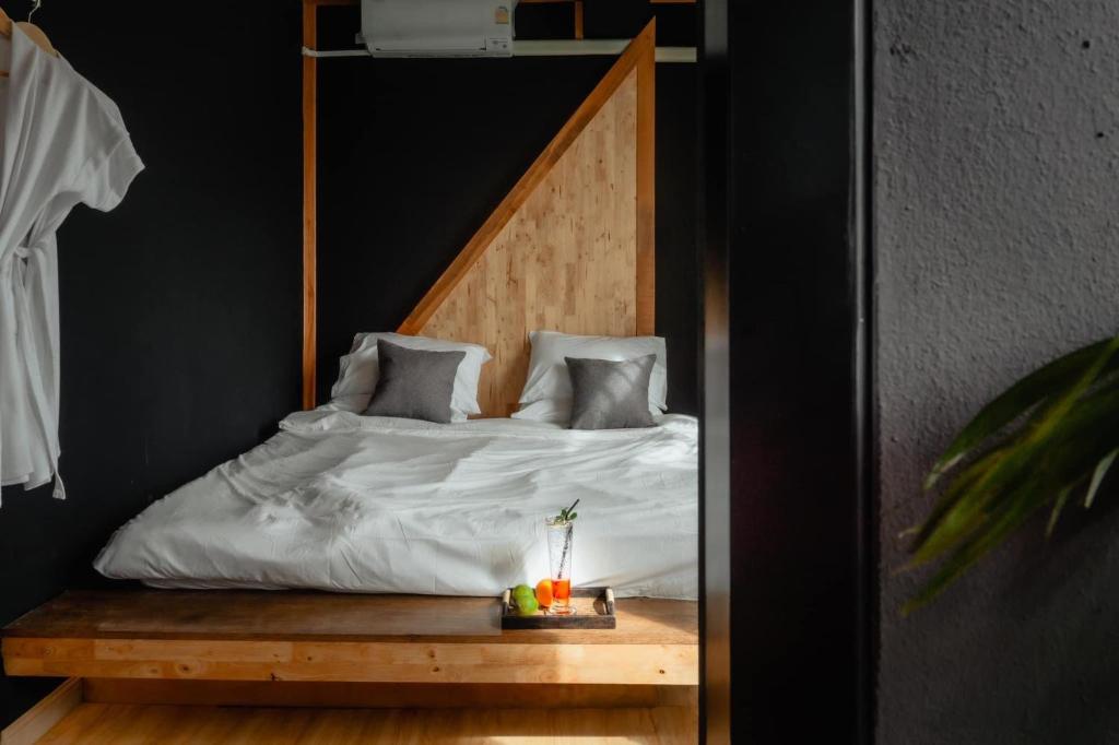 - une chambre avec un lit et une tête de lit en bois dans l'établissement JADAE HOUSE Doichang, à Ban Huai Khai