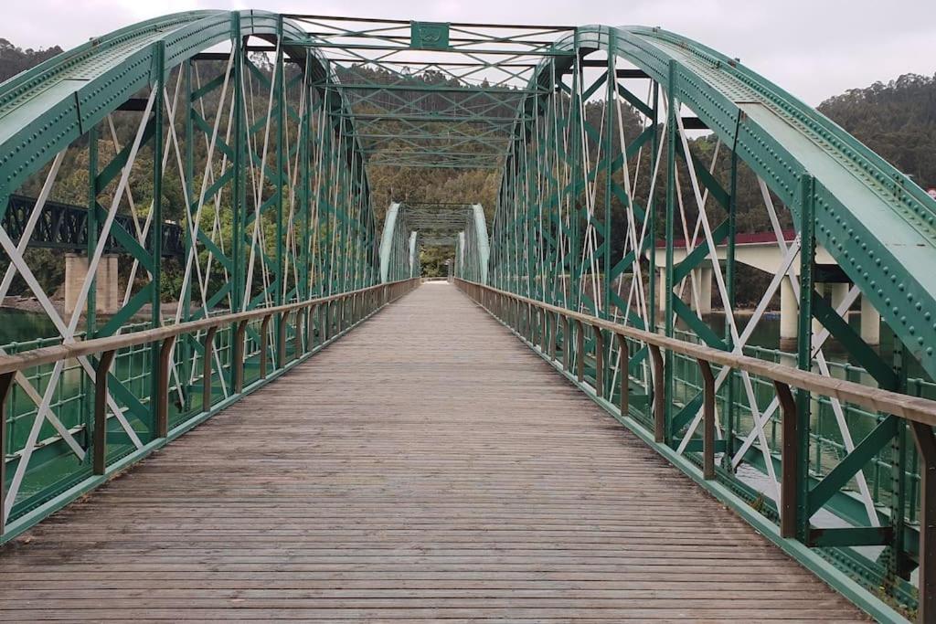 een brug met een houten loopbrug erop bij PIEDAD FERNANDEZ FERNANDEZ GESTION DE INMUEBLES - III in O Barqueiro