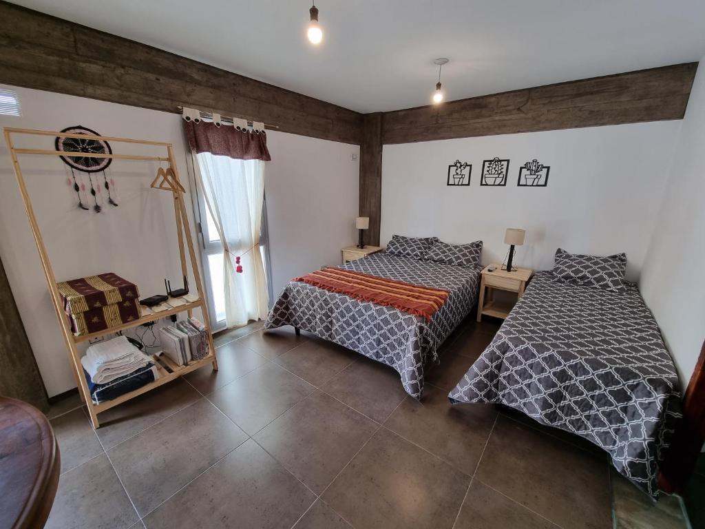 1 dormitorio con 2 camas y espejo en Monoambiente temporal Jujuy en San Salvador de Jujuy