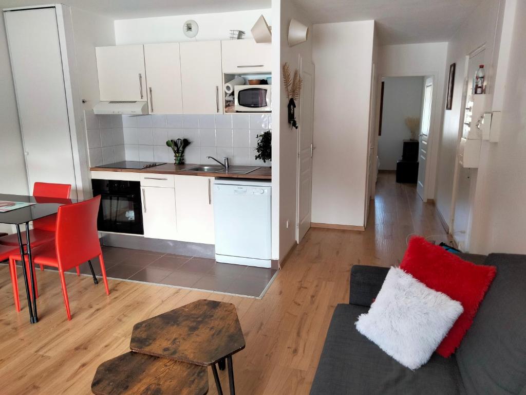 een woonkamer en een keuken met een bank en een tafel bij charmant T2 formiguères les esplaneilles in Formiguères