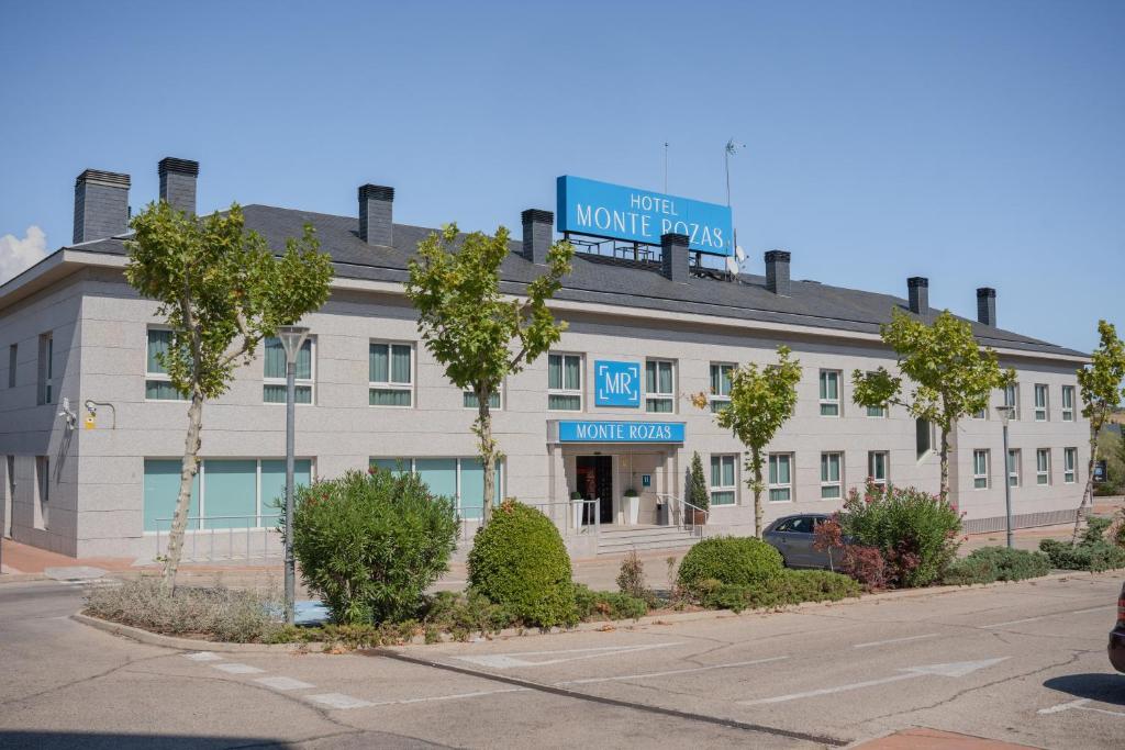 Un bâtiment blanc avec un panneau en haut dans l'établissement Hotel Monte Rozas, à Las Rozas de Madrid