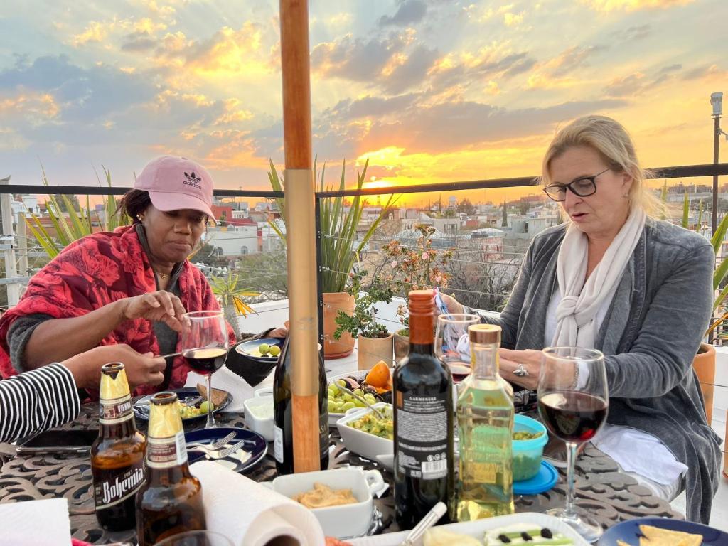 two women sitting at a table with wine glasses at Un punto- 2 Bedroom Apartment in San Miguel de Allende