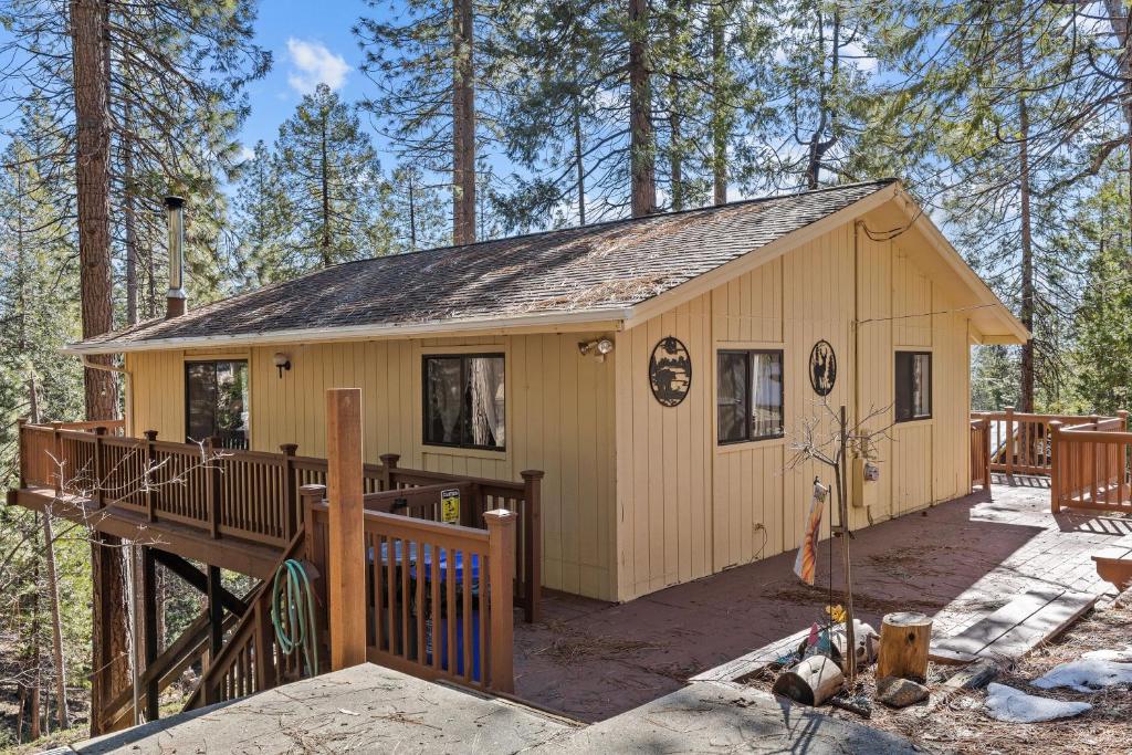 ein winziges Haus im Wald mit einer Terrasse in der Unterkunft Big Trees, Little Cabin in Arnold