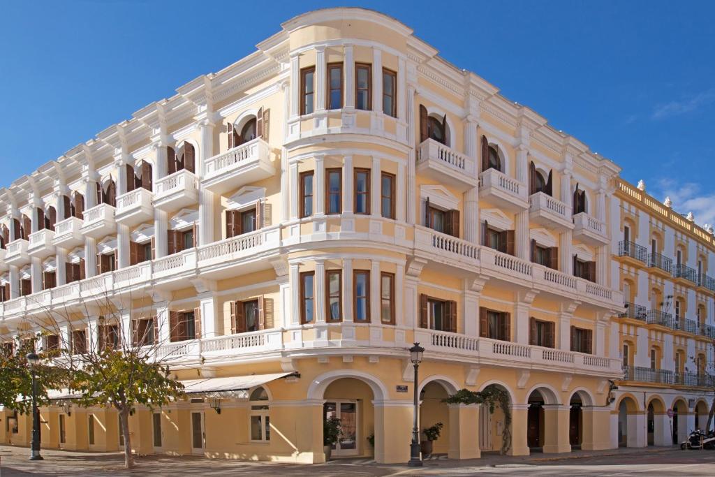 Un grand bâtiment blanc avec balcon se trouve dans une rue. dans l'établissement Montesol Experimental Ibiza, à Ibiza