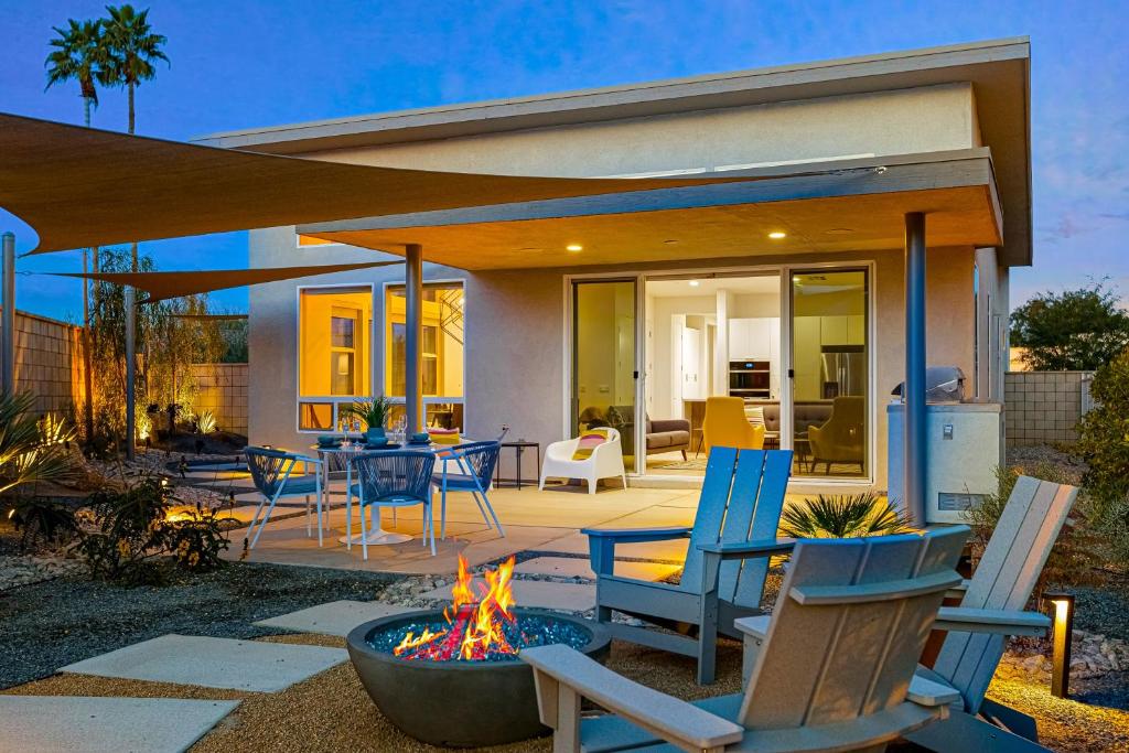 a patio with chairs and a fire pit in front of a house at Artfully Indian Wells in Indian Wells