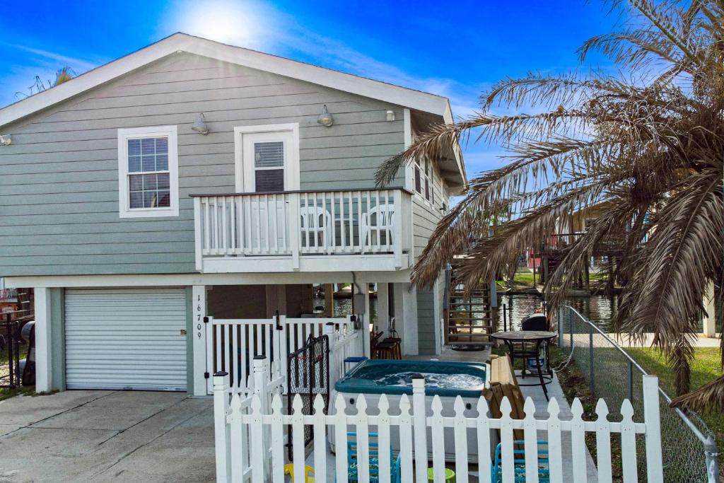 una casa con una cerca blanca delante de ella en Bungalow by the Bay en Galveston
