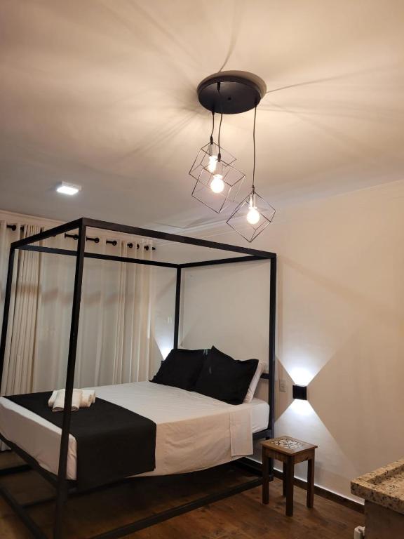 a bedroom with a bed with a black canopy at Pelourinho Boutique Hotel - OH HOTÉIS in Salvador