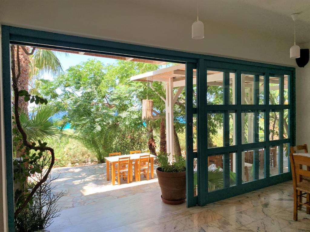 an open sliding glass door to a patio with a table at Hotel Plakures in Falasarna