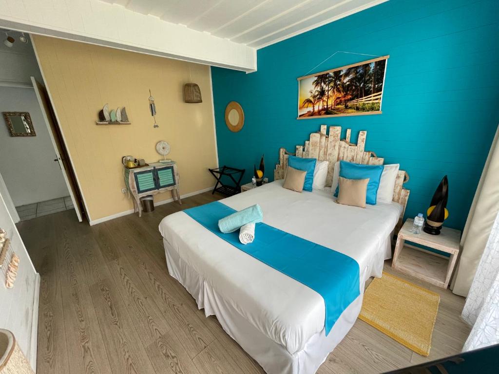 um quarto com uma cama grande e paredes azuis em La Villa Soalic em Cilaos