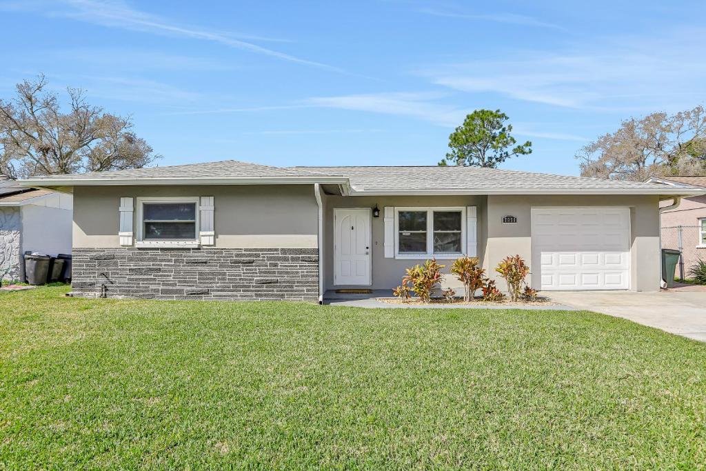 a house with a lawn in front of it at Pinellas Retreat in Pinellas Park