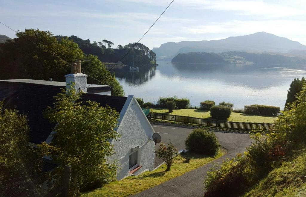 a house on a hill with a view of a lake at Tarradale Cottage in Portree