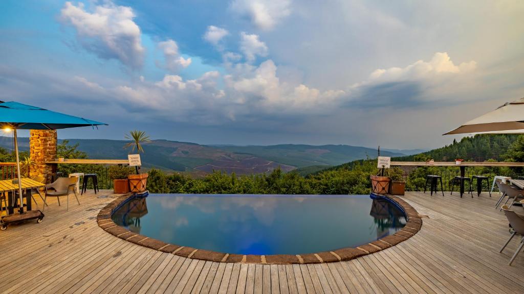 a pool on a deck with a table and chairs at Misty Mountain in Sabie