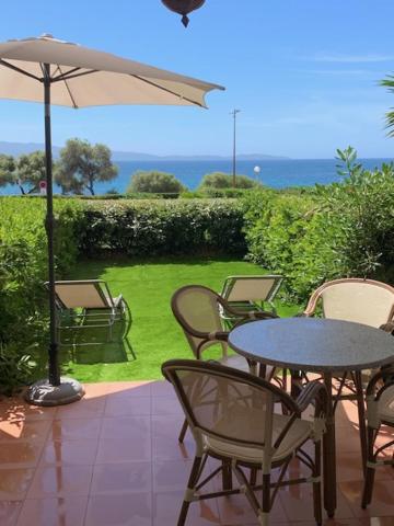 eine Terrasse mit einem Tisch, Stühlen und einem Sonnenschirm in der Unterkunft Apt. T1 Superbe vue Mer in Ajaccio